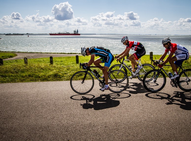 Wielrenners in de Zeeuwse natuur. Wielrennen in Zeeland is heel divers en bied wielrenners fantastische routes en mooie omgevingen.