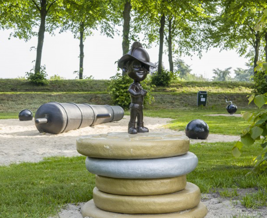 Speeltuin met gouden en zilveren munten met een pagadder op de uitkijk. Op de achtergrond een kanon om op te spelen.