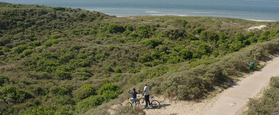 Twee mountainbikers bij Westerschouwen kijken uit op zee